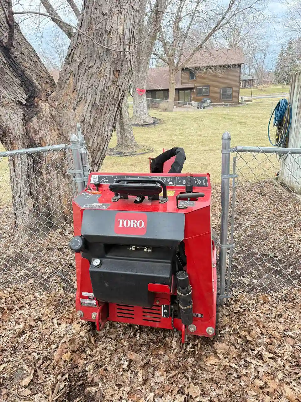 Stump grinder working near chain-link fence — tight access job in Twin Cities